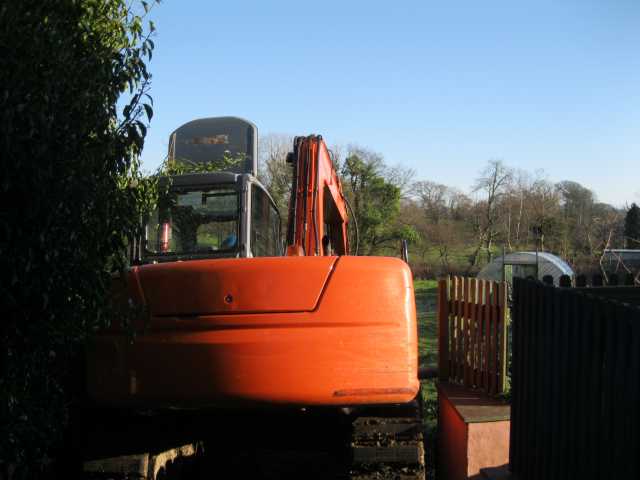 Digger edges into field with a centimetre to spare on either side!